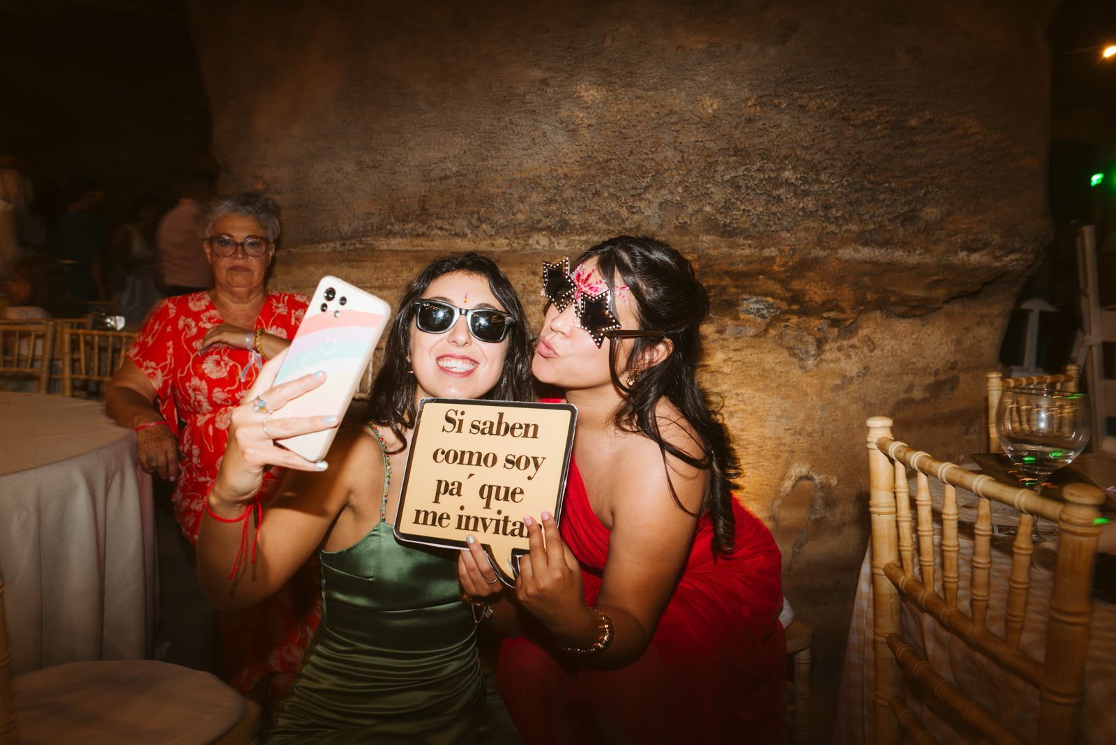Invitadas en una boda en Gran Canaria durante la fiesta con un cartel en la mano haciéndose un selfie