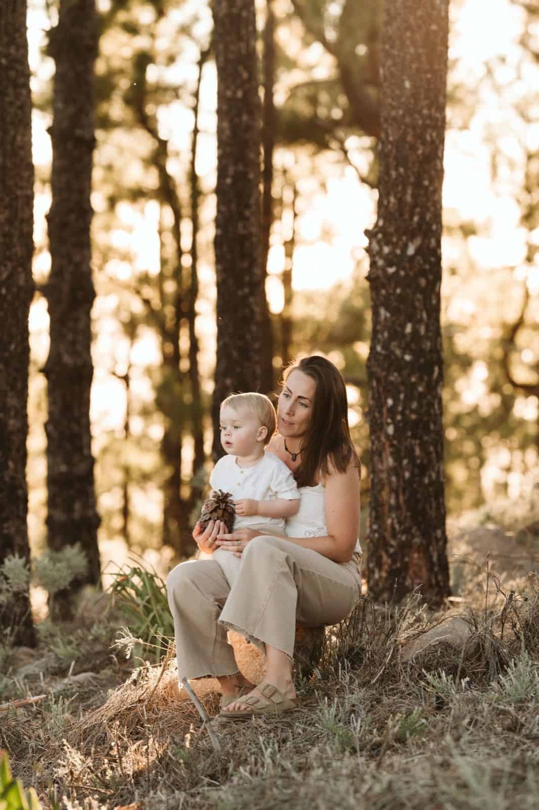 Niño pequeño sentado en el regazo de su madre mirando en la cumbre de Gran Canaria