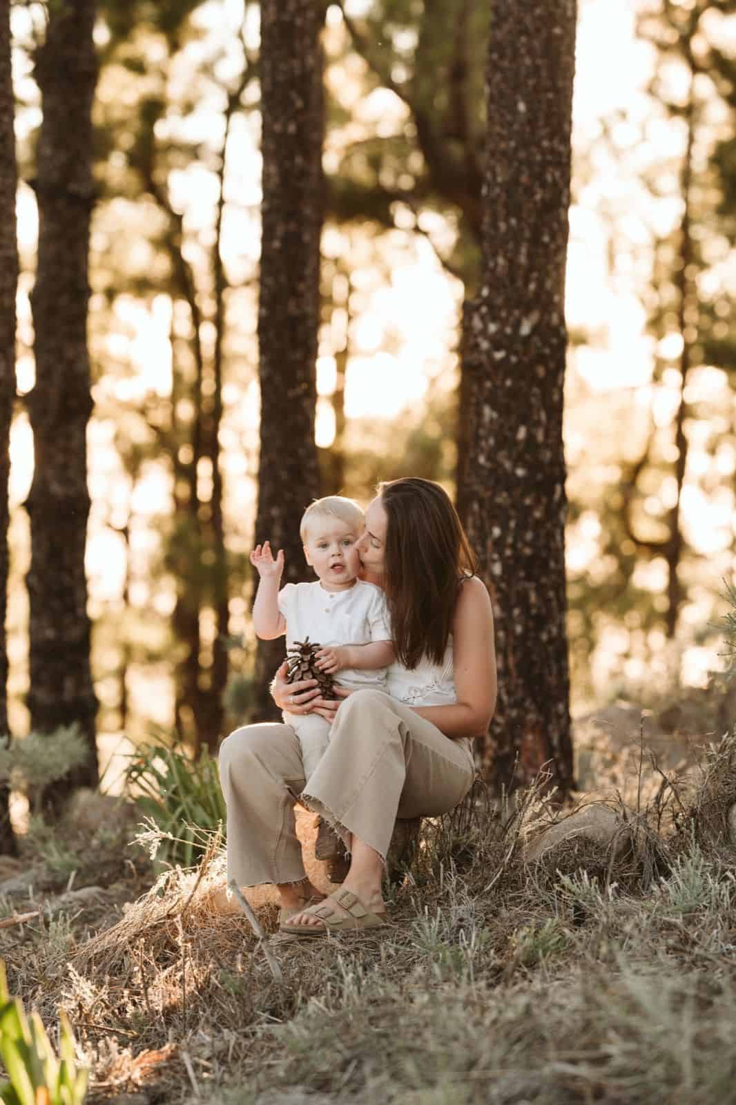 Niño pequeño sentado en el regazo de su madre mirando en la cumbre de Gran Canaria
