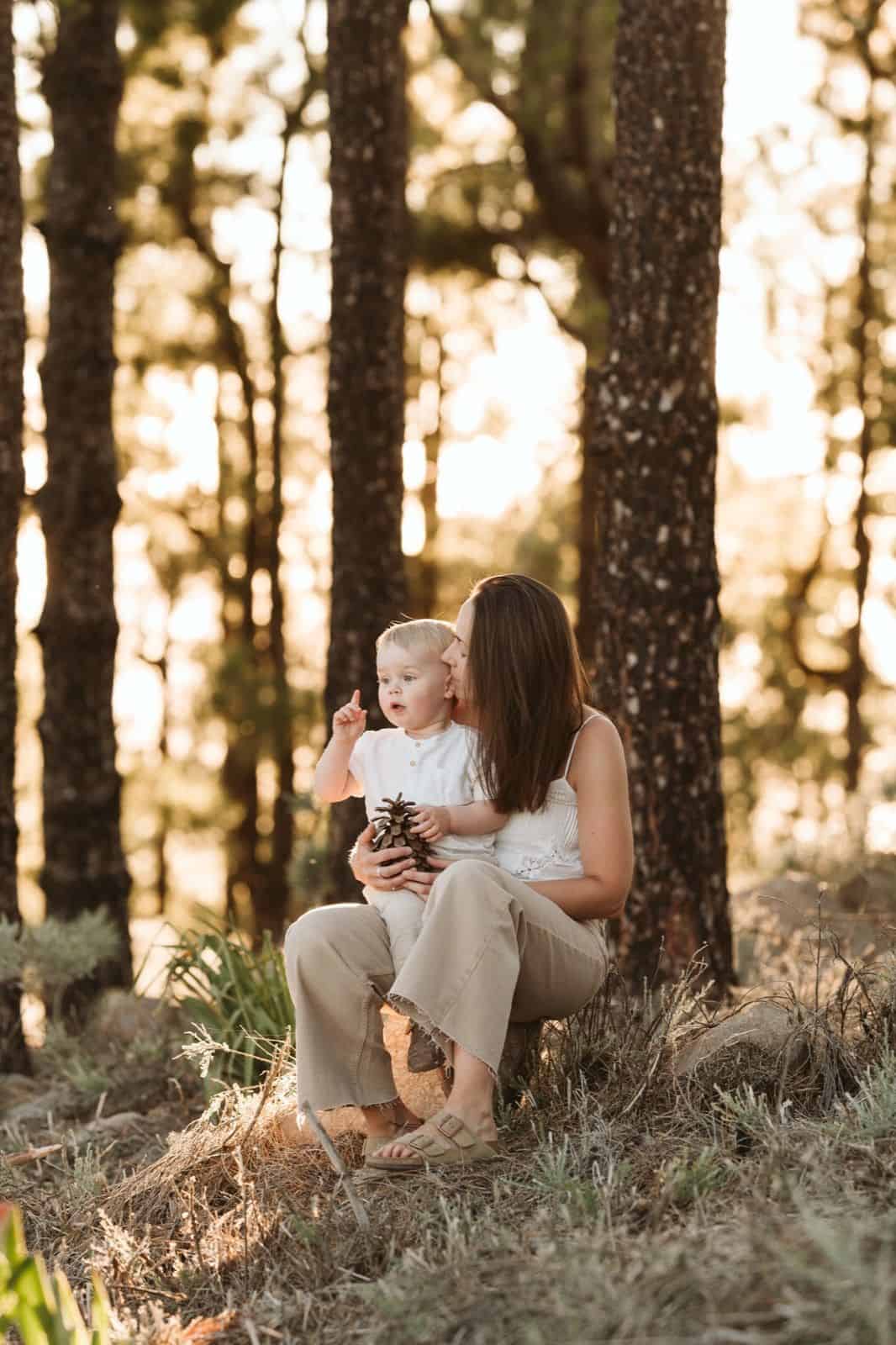 Niño pequeño sentado en el regazo de su madre mirando en la cumbre de Gran Canaria