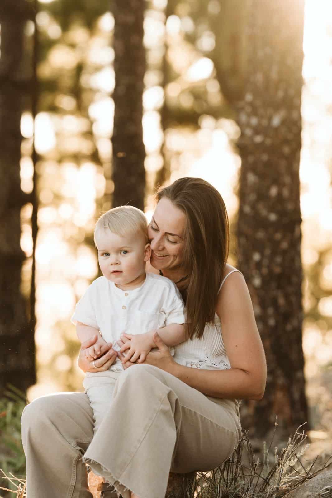 Familia de madre e hijo pequeño posando frente a la cámara y sonriendo