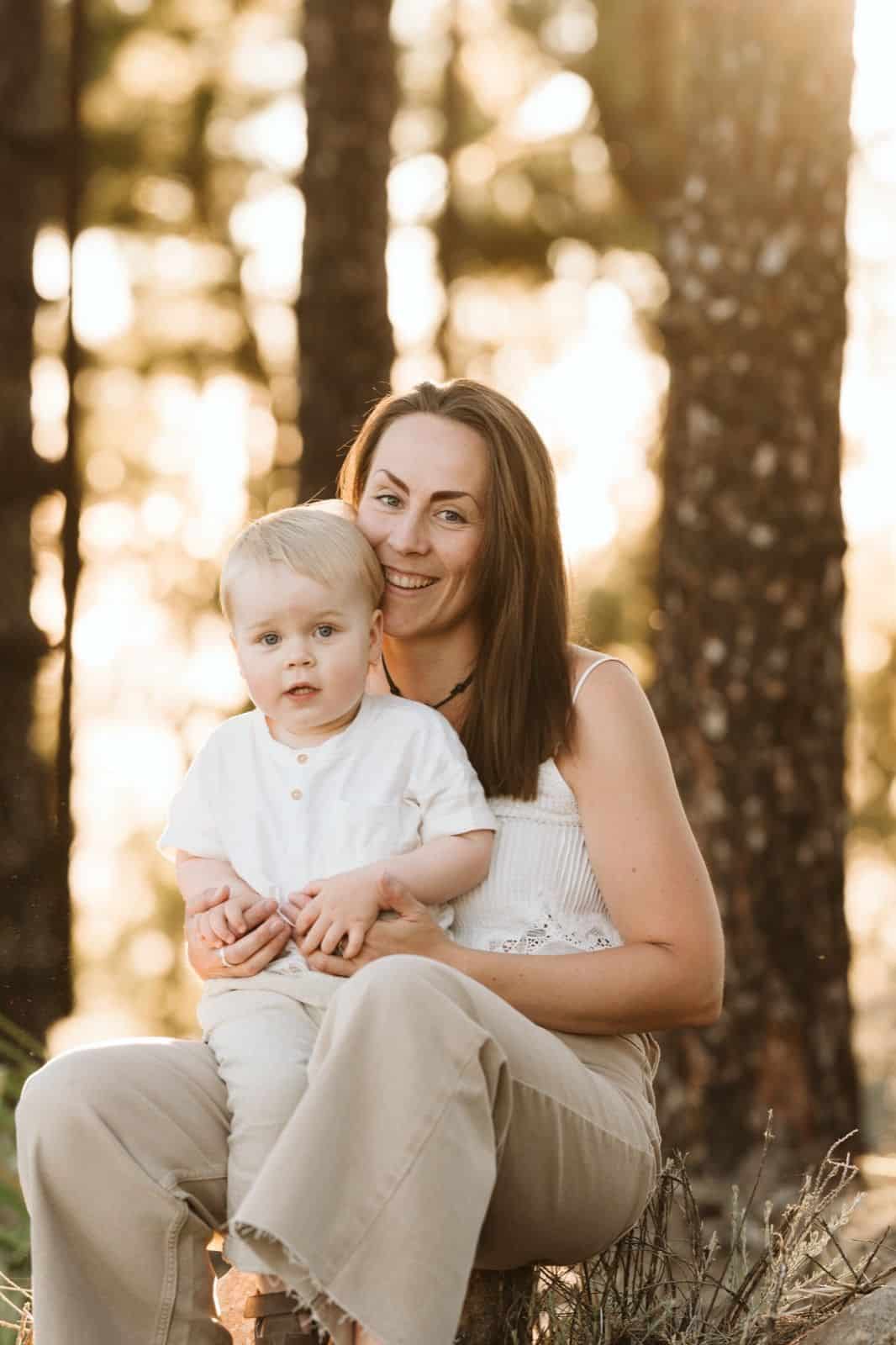 Familia de madre e hijo pequeño posando frente a la cámara y sonriendo