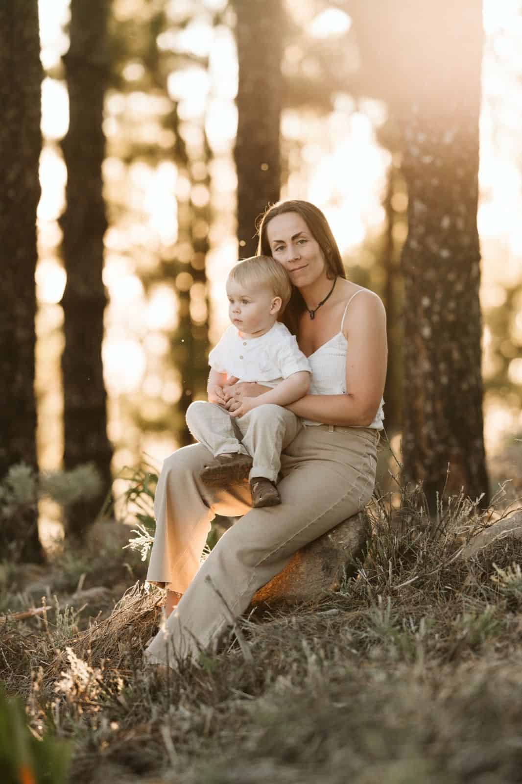 Niño pequeño sentado en el regazo de su madre mirando en la cumbre de Gran Canaria