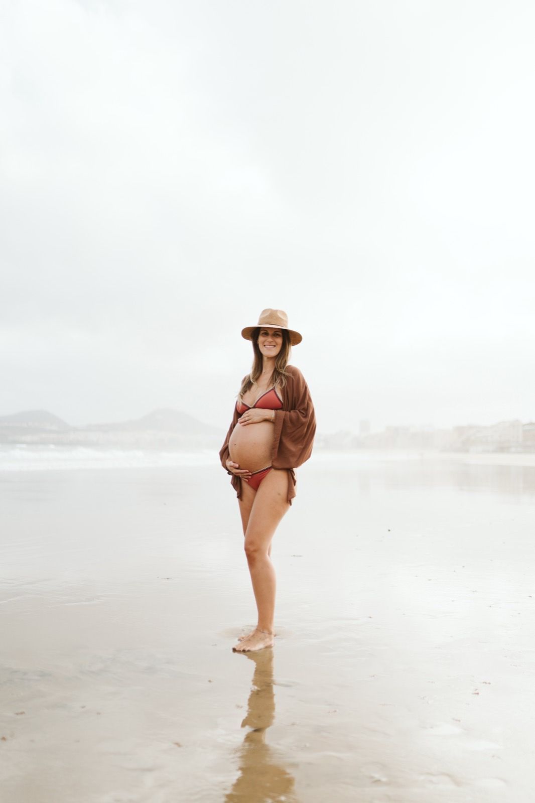 Mujer embarazada posando con serenidad en la arena de la playa de Las Canteras, Gran Canaria
