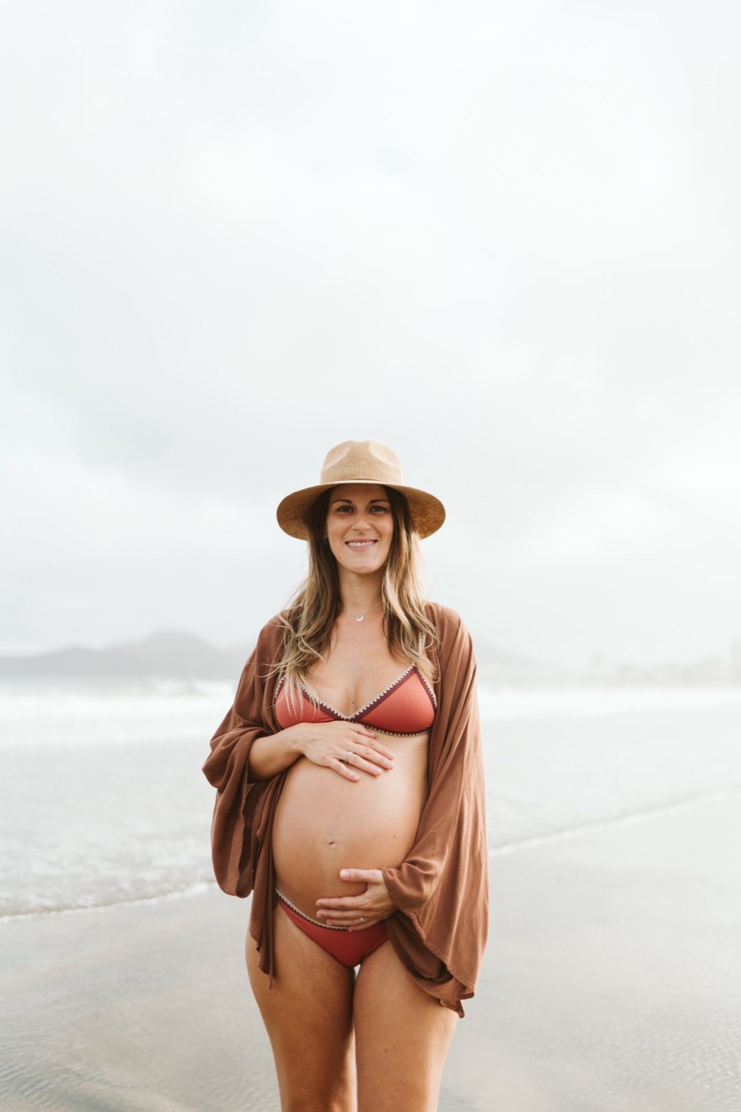 Futura madre posando con orgullo en la playa de Las Canteras, mostrando su barriga de embarazo
