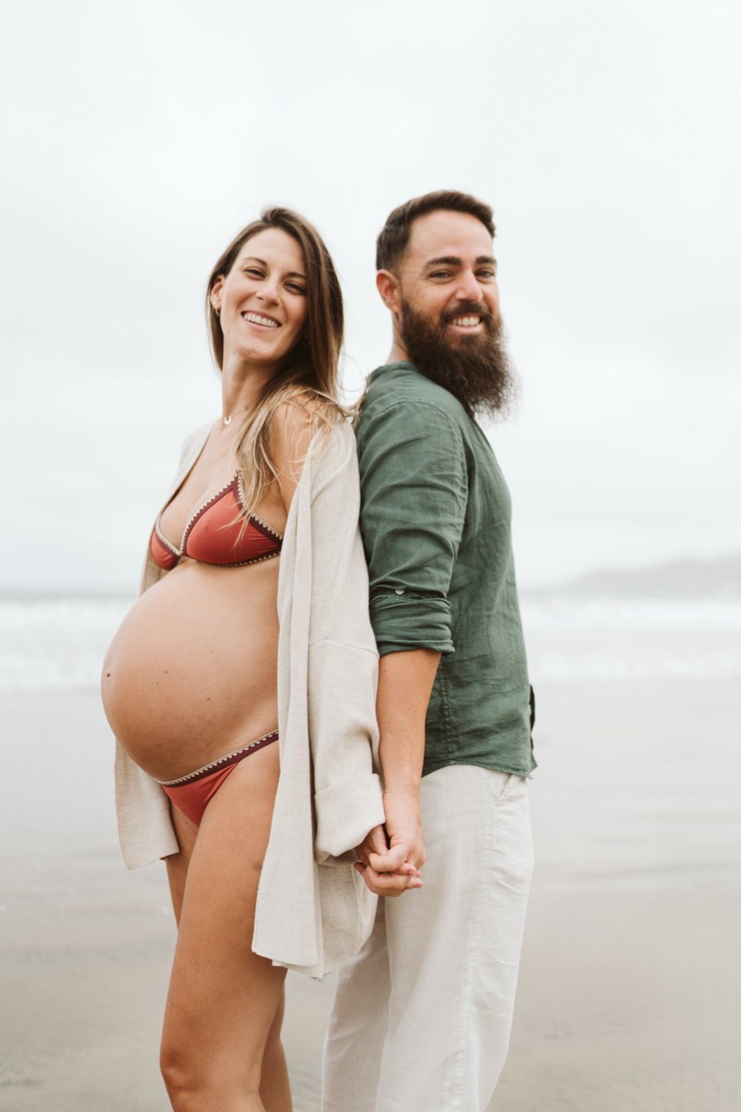 Futura madre y su pareja compartiendo un momento romántico en la arena de Las Canteras, Gran Canaria