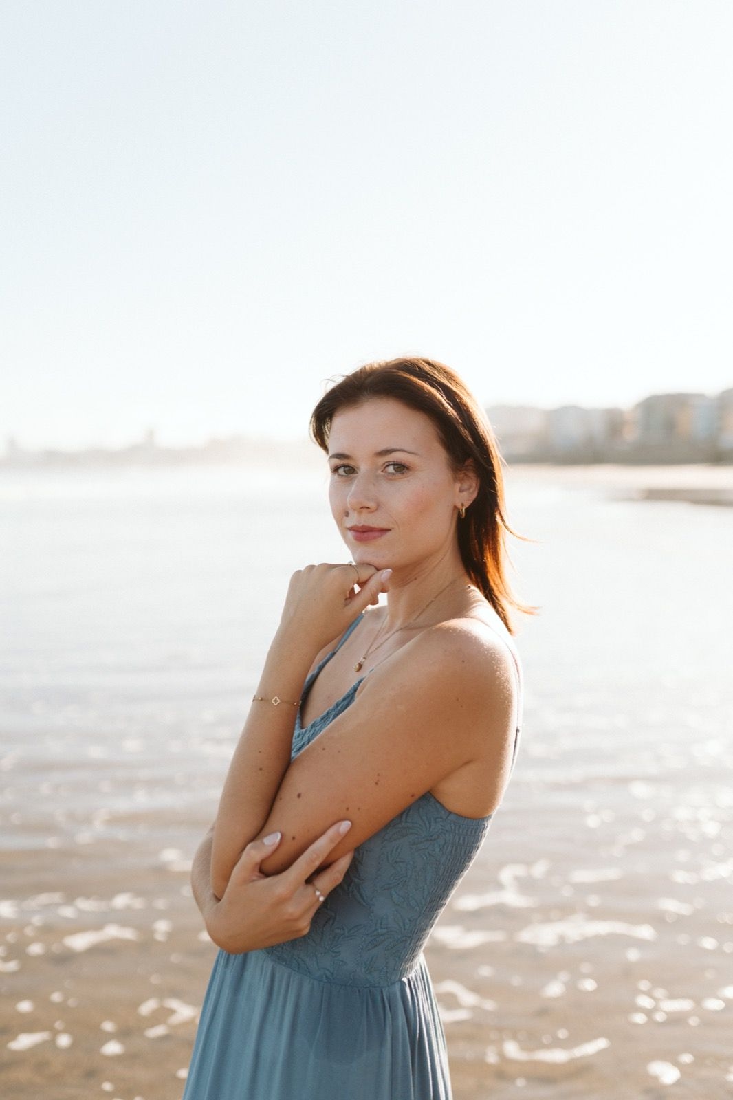 Mujer posando a la cámara sonriendo en la orilla de la Playa de Las Canteras en Gran Canaria durante las horas de marea baja. Fotografía realizada por el fotógrafo de familias en Gran Canaria Héctor Cardeñosa.