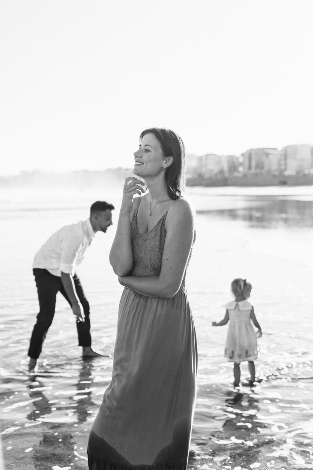 Mujer posando a la cámara sonriendo en la orilla de la Playa de Las Canteras en Gran Canaria durante las horas de marea baja. Fotografía realizada por el fotógrafo de familias en Gran Canaria Héctor Cardeñosa.