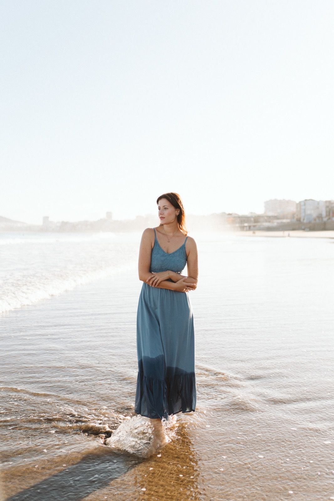Mujer posando a la cámara sonriendo en la orilla de la Playa de Las Canteras en Gran Canaria durante las horas de marea baja. Fotografía realizada por el fotógrafo de familias en Gran Canaria Héctor Cardeñosa.