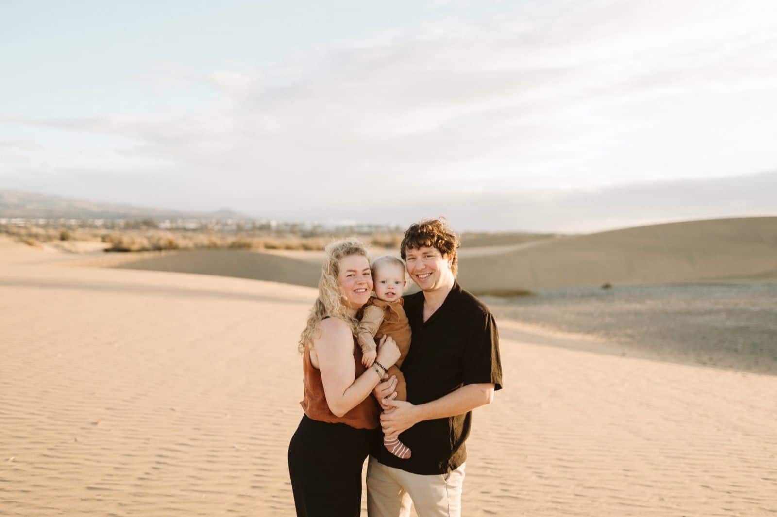 Retrato de una familia caminando por la playa de Maspalomas durante una sesión fotográfica