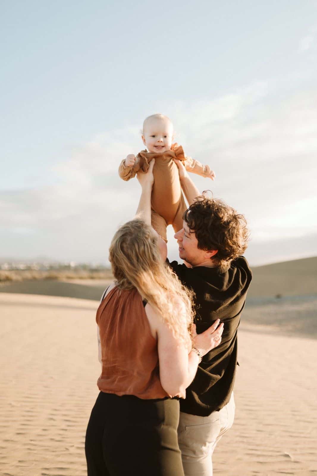 Retrato de una familia caminando por la playa de Maspalomas durante una sesión fotográfica