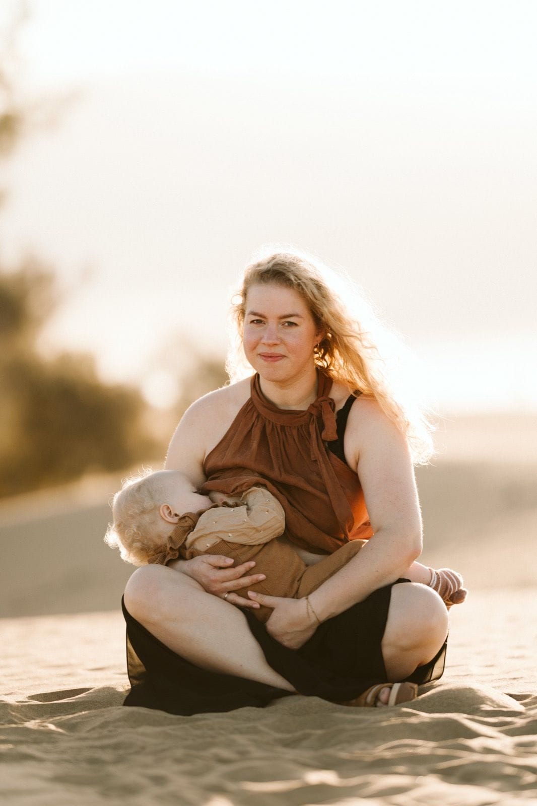 Mamá dandole el pecho a su bebé en un descanso de la sesión de fotos en las Dunas de Maspalomas en Gran Canaria