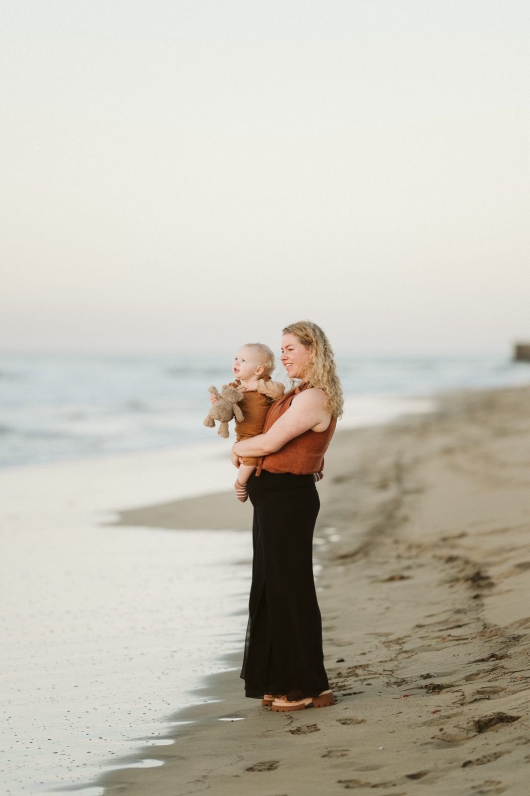 Madre enseñándole el mar a su bebé a orillas de la Playa de Maspalomas en Gran Canarias durante unas fotos familiares