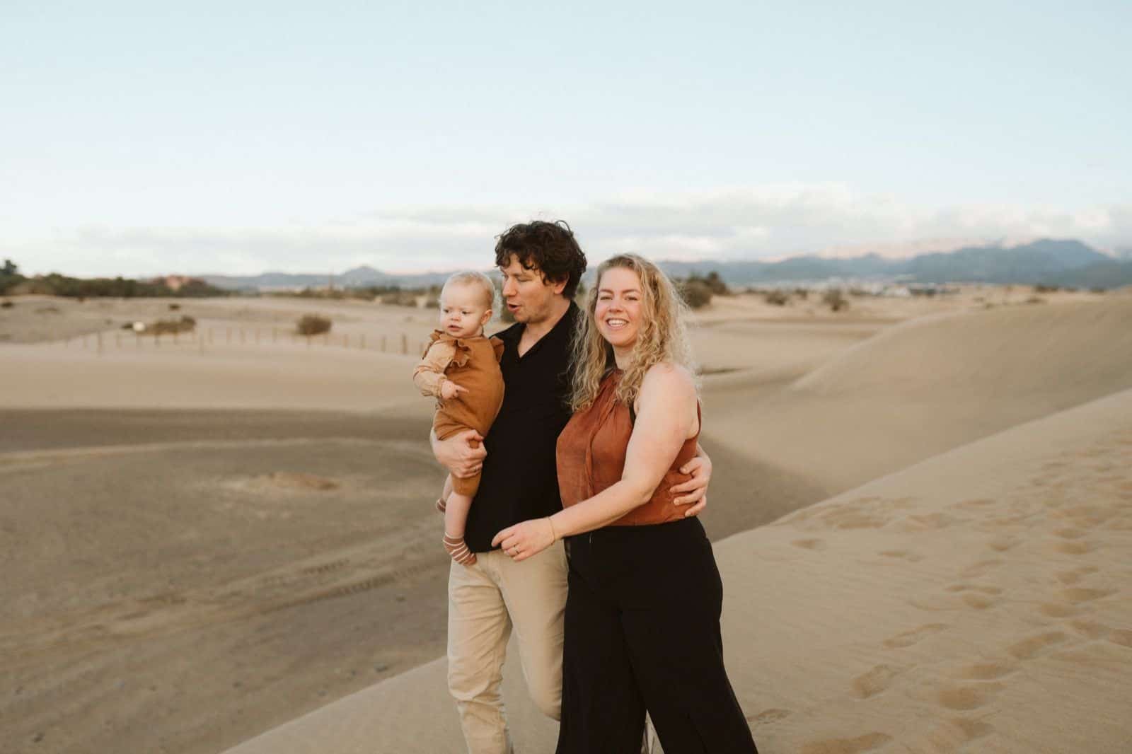 Pareja con su hijo en una sesión de fotos familiares en Maspalomas, rodeados de naturaleza durante el atardecer